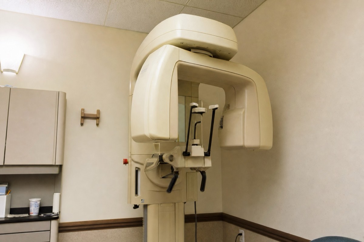 An older beige CBCT unit in a dental office